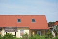 Rural cottage with red metal roof and attic skylight windows Royalty Free Stock Photo