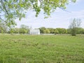 A rural country church with a white fence sits peacefully next to a green pasture. Royalty Free Stock Photo