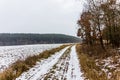 Rural countryside road on a winter day with fields and snow. Royalty Free Stock Photo