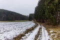 Rural countryside road on a winter day with fields and snow. Royalty Free Stock Photo