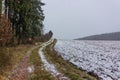 Rural countryside road on a winter day with fields and snow. Royalty Free Stock Photo