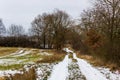 Rural countryside road on a winter day with fields and snow. Royalty Free Stock Photo