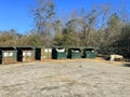 A rural county public waste trash dump for local residents lined up dumpsters and trash pile