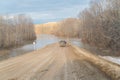 A rural dirt road flooded with water