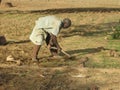 Rural Farmer in Burkina Faso struggles to prepare dry, hard ground