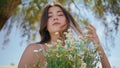 Rural girl touching hair hold wildflowers closeup. Happy woman enjoying bouquet Royalty Free Stock Photo