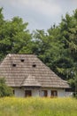 Rural house with shingles, seen thru a poppy field