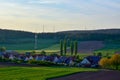 Rural houses with solar panels on the roofs. Plowed fields are in the foreground. Wind power plants in the background Royalty Free Stock Photo