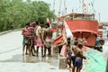 Rural Indian fishermen community standing near Fishing boat in coastal poor area fishing village before sailing river sea for Royalty Free Stock Photo