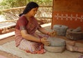 Rural Indian woman figure using stone grinder to make flour