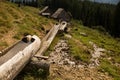 Rural irrigation canal flowing through wooden pipes in the village Royalty Free Stock Photo