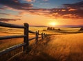 A rural landscape adorned with fields of verdant grass, harmonizing with the hues of a setting sun in the background. Royalty Free Stock Photo