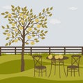 Rural landscape with apple tree and table and chairs Royalty Free Stock Photo
