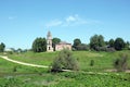 Rural landscape with hills, river, a village and christian church ruins far away