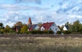 Rural landscape with old houses and church in the middle of the field Royalty Free Stock Photo