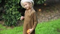 Adorable little girl picking fresh ripe oranges in sunny orange tree garden in Italy