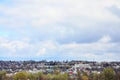 A rural landscape with many private houses and green trees. Suburban panorama on a cloudy afternoon. A place far from the cit