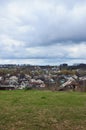 A rural landscape with many private houses and green trees. Suburban panorama on a cloudy afternoon. A place far from the cit