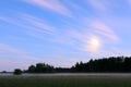 Rural landscape by night. Moon above wood and field with evening fog, magical atmospheric mood. Long exposure shot