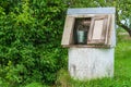 Rural landscape. Old-fashioned well with a metal bucket in the g Royalty Free Stock Photo