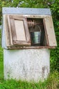 Rural landscape. Old-fashioned well with a metal bucket in the g Royalty Free Stock Photo