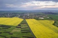 Rural landscape on spring or summer day. Aerial view of green, plowed and blooming fields, house roofs on sunny dawn. Drone Royalty Free Stock Photo