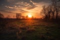 rural landscape with sun setting behind the horizon, casting warm colors across the sky