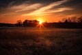 rural landscape with sun setting behind the horizon, casting warm colors across the sky