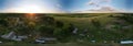Rural landscape at sunset. Green landscape, sun on the horizon and blue sky. Aerial photography panorama. Royalty Free Stock Photo