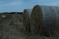 Rural landscape two haystacks bales of hay straw lying on a field close up in warm or cold light