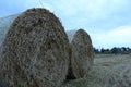 Rural landscape two haystacks bales of hay straw lying on a field close up in warm or cold light