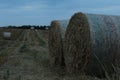 Rural landscape two haystacks bales of hay straw lying on a field close up in warm or cold light