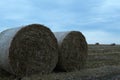 Rural landscape two haystacks bales of hay straw lying on a field close up in warm or cold light