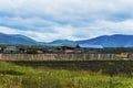 Rural landscape. Village in the foothills of the Sayan Mountains. Eastern Siberia. Wooden fence and roofs of houses Royalty Free Stock Photo