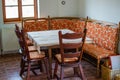 Rural living room of a country house with some wooden chairs, a sofa and a table with a tablecloth. Cozy and antique place