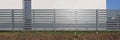 The rural long fence is made of horizontal wooden boards and painted with gray oil paint panorama Royalty Free Stock Photo