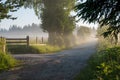 Rural macadam road that runs between wooden fences