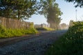 Rural macadam road that runs between wooden fences Royalty Free Stock Photo