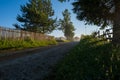 Rural macadam road that runs between wooden fences Royalty Free Stock Photo