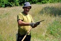 Rural man using scythe