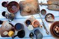 Rural meal of antique utensils, vintage scales and simple rustic foods on a white tablecloth outdoors, top view