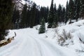 Rural mountain road completely covered with snow, with car rides Royalty Free Stock Photo