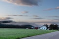 Rural Norway countryside morning sunrise view. Nice small nordic houses, green grass fields Royalty Free Stock Photo