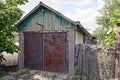 Rural old garage with wooden loft and iron red rusty gates Royalty Free Stock Photo