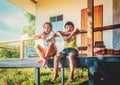 Rural children in Thailand Rural area is sitting in the balcony of a wooden farm house house for Country poverty concept Royalty Free Stock Photo