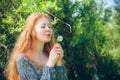 Rural red-haired girl with a dandelion