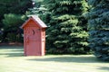 rural red outhouse privy toilet building forest glade Royalty Free Stock Photo