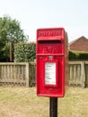 Rural red royal mail box rustic outside street village Royalty Free Stock Photo