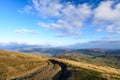 Rural road in autumn background. Mountain rural road with water Royalty Free Stock Photo