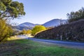 Rural road bend among hills and trees.